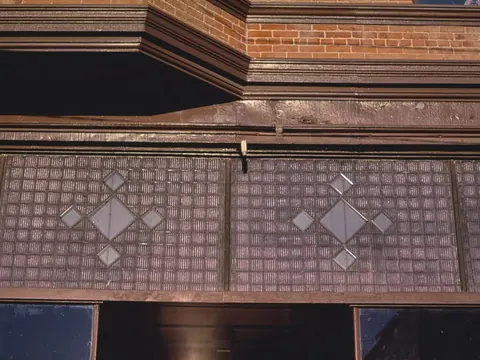 A patterned glass transom over a Main Street storefront